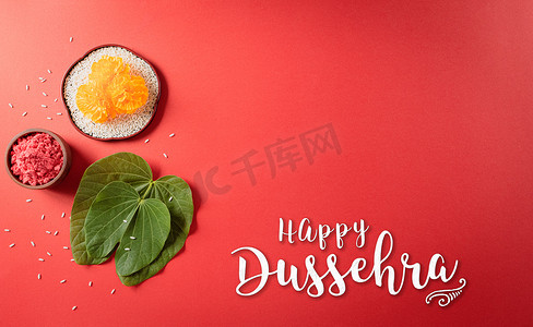 快乐的杜塞赫拉。黄色的花，绿色的叶子和红色背景的米。Dussehra印第安人节的概念.