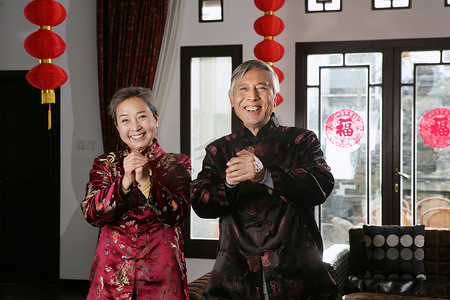 拜年手势摄影照片_中国老年夫妇拜年