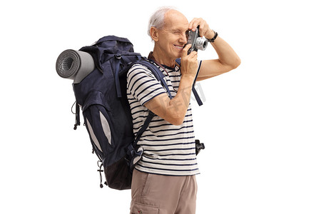 老人徒步旅行者用照相机拍一张照片