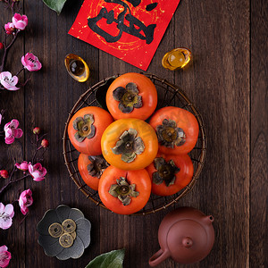 在中国农历新年水果设计理念的木桌背景上，人们可以看到新鲜甜甜的桂树和树叶，这个词的意思是祝福即将到来.