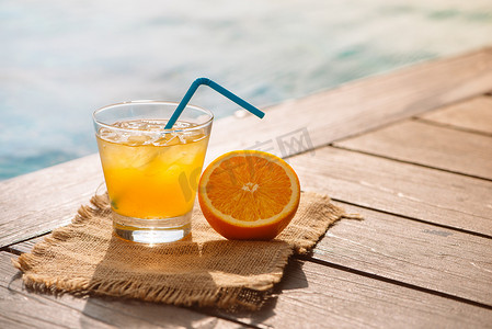 关闭的螺丝刀鸡尾酒酒精饮料与橙汁, 切片和冰站在池边。在池畔的玻璃杯中清爽冰柠檬汁饮料。孙瞪。背景, 复制空间.