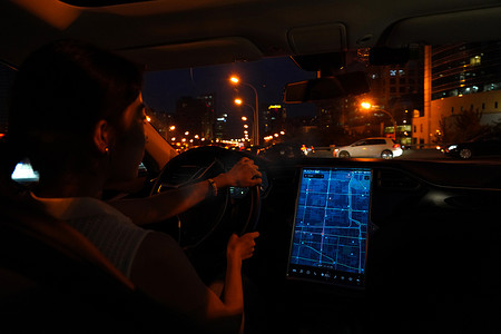 夜晚按屏幕地图开车的青年女人