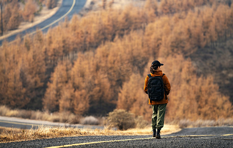 旅游探险摄影照片_年轻女子户外徒步旅行的背影