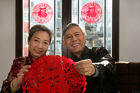 中国老年夫妇手拿福字剪纸