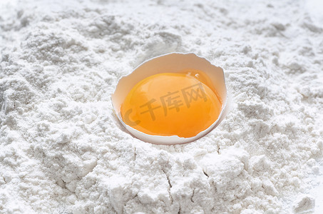 线描元素摄影照片_小麦面粉中的新鲜鸡蛋以白色背景为包装设计元素。顶部视图