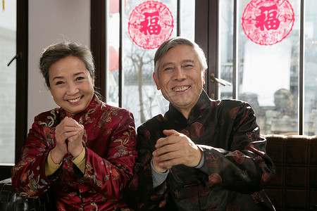 拜年剪纸摄影照片_中国老年夫妇拜年