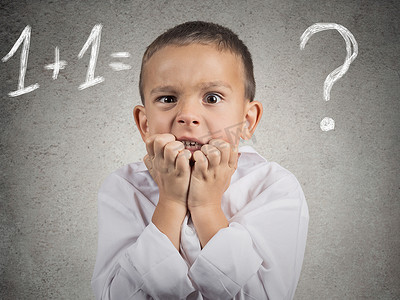数学测验卷摄影照片_试图解决数学问题的困惑、 焦虑的男孩
