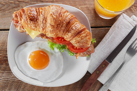 鸡蛋三明治摄影照片_与炒的腊肉奶酪番茄早餐和鸡蛋三明治牛角面包