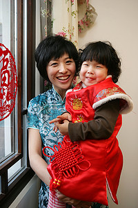 孩子过年摄影照片_中国年轻妈妈抱着孩子