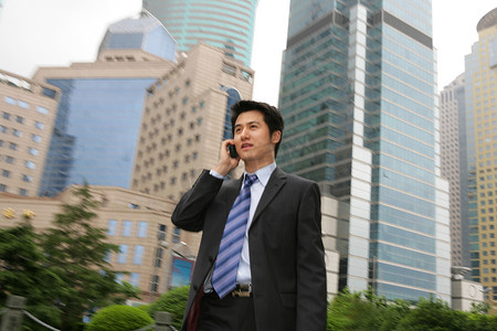 建筑手机摄影照片_上海浦东写字楼旁一位男商务人士打手机