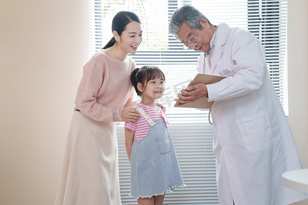 年轻亚洲家庭摄影照片_年轻妈妈带着孩子看医生