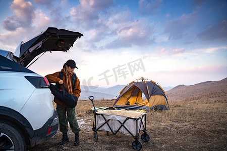 自驾旅游摄影照片_自驾的年轻女人准备露营