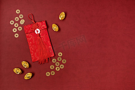 中国新年装饰比红色背景。传统的农历新年红包，金锭与文字意味着好运，繁荣，财富。平躺在地上，俯瞰四周