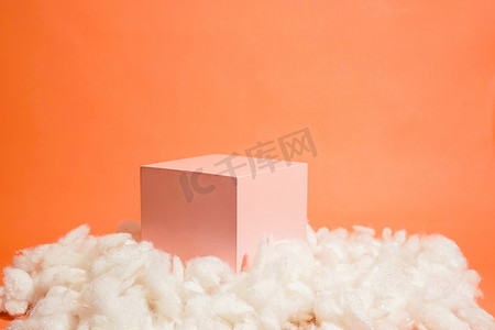products摄影照片_product platform arrangement in pink pastel color decorated with cotton as clouds. trendy display layout with an empty podium for showcasing cosmetics, skincare, or other products.