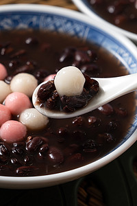 将红白相间的汤圆（汤圆，糯米团）与甜甜的红豆汤一起放在白桌上，准备过冬.