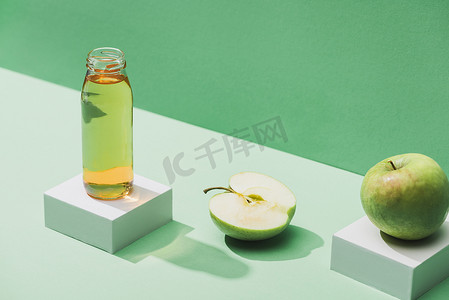 and摄影照片_fresh juice near apples and and white cubes on green and turquoise background