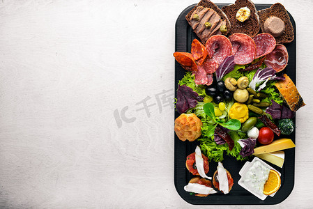 意大利菜一大套。奶酪、 香肠、 肉和腌渍的蔬菜在木板上。顶视图。可用空间.