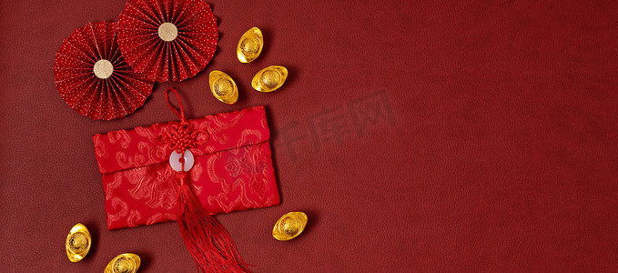 中国新年装饰比红色背景。传统的农历新年红包，纸迷和金锭，文字代表着好运，繁荣，财富。平铺、俯瞰、横幅
