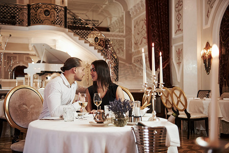 Looking at each other. Beautiful couple have romantic dinner in luxury restaurant at evening time.