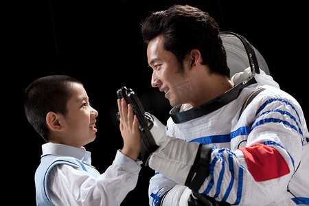 儿童理想摄影照片_小男孩和宇航员手牵手