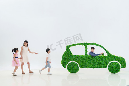 绿色清新环保摄影照片_一家人准备驾驶绿色环保汽车出行