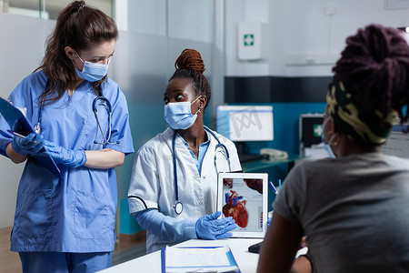 hospital摄影照片_African american cardiologist doctor showing heart radiohraphy to sick patient