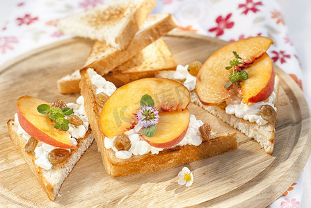 烤面包，奶酪，葡萄干和新鲜熟透的水蜜桃