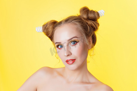 黄色五角星边框摄影照片_年轻的美女女孩与发角电灯发型在黄色背景