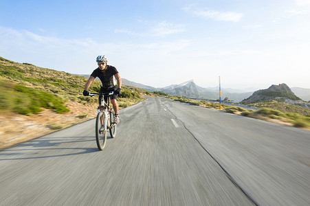 骑自行车的人男子骑山地自行车在晴朗的一天的山路上