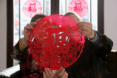 中国老年夫妇手拿福字剪纸