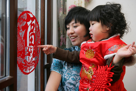 红色福字中国结摄影照片_中国年轻妈妈和孩子一起玩