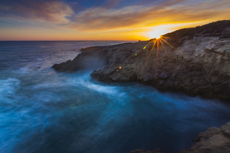 在加利福尼亚马里布Leo Carrillo州海滩的层序点上，避免了长期曝光的光波在日落时与岩层相撞的景象