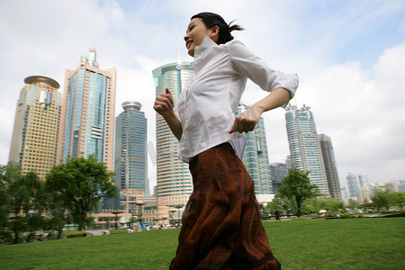 上海浦东写字楼前草坪上一位女商务人士奔跑
