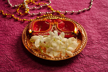 在Diwali庆典期间，粘土灯用白花点亮。设计名为Diwali的印度印度教灯节贺卡.