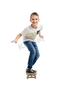 快乐微笑的男孩骑着滑板