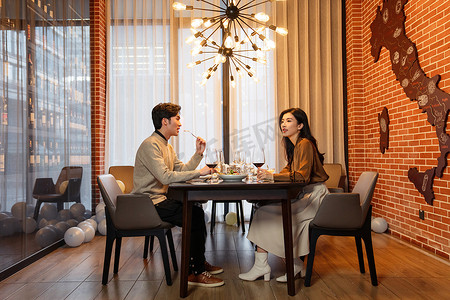 温馨美食摄影照片_青年伴侣在餐厅用餐