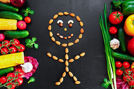 健康的食物背景。食用新鲜蔬菜的健康食品概念和一些种类的坚果作为 stickman.