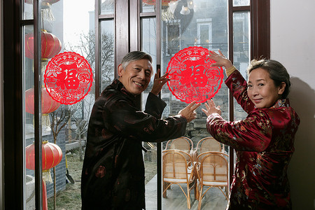 法治剪纸摄影照片_中国老年夫妇贴窗花