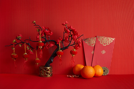 中国新年装饰品。橙子，叶子，红包，梅花红色背景.