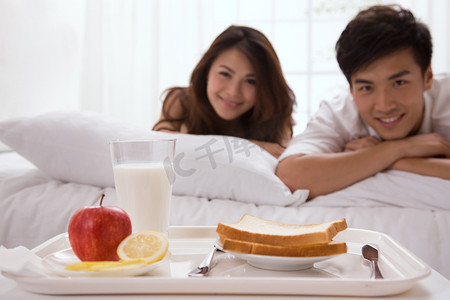 美女托盘摄影照片_年轻夫妇床前的早餐