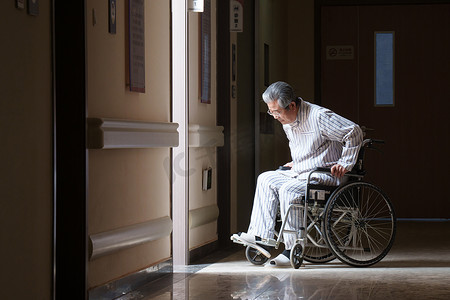 悲哀摄影照片_走廊内坐在轮椅上的老人