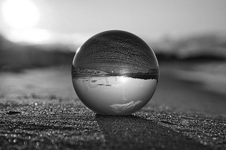 Glass globe on the beach of the Baltic Sea in Zingst in which the landscape is depicted. Implemented in black and white.