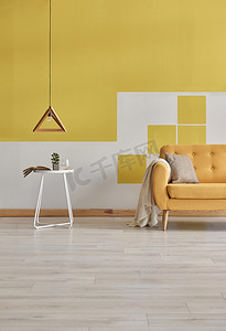 黄色和白色的墙壁家庭客厅的概念。橙色沙发与灯装饰。现代黄色墙壁背景