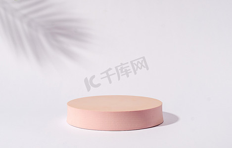 Disc cylinder mock up platform pedestal stand pink for advertising product on gray background and shadow palm and copy space. Minimal trend concept.