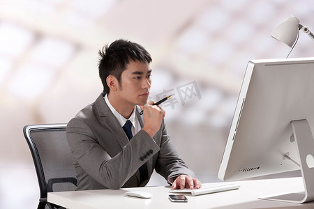 青年商务男士在办公室里看电脑
