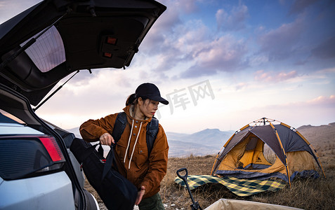 人拉车摄影照片_自驾的年轻女人准备露营
