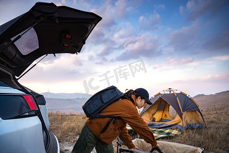 人拉车摄影照片_自驾的年轻女人准备露营
