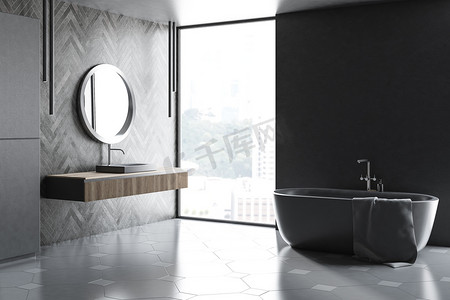 现代浴室的角落, 有灰色和黑色的木墙, 阁楼窗口, 灰色浴缸和灰色水槽在木柜台上, 上面有圆形的镜子。3d 渲染