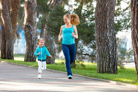 体育家庭。妈妈和宝宝女儿慢跑上自然的运行