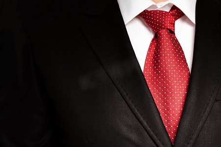 红色领带摄影照片_黑色西装与红色领带的商人